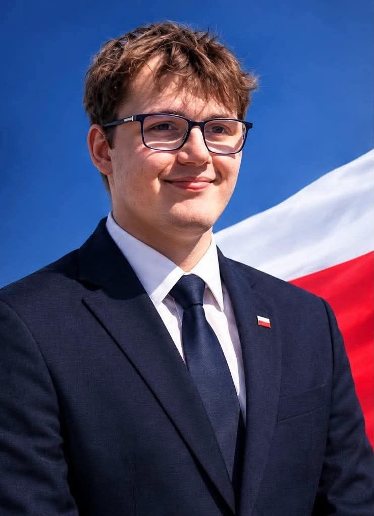 Błażej Bauer — portret kandydata na tle flagi Polski